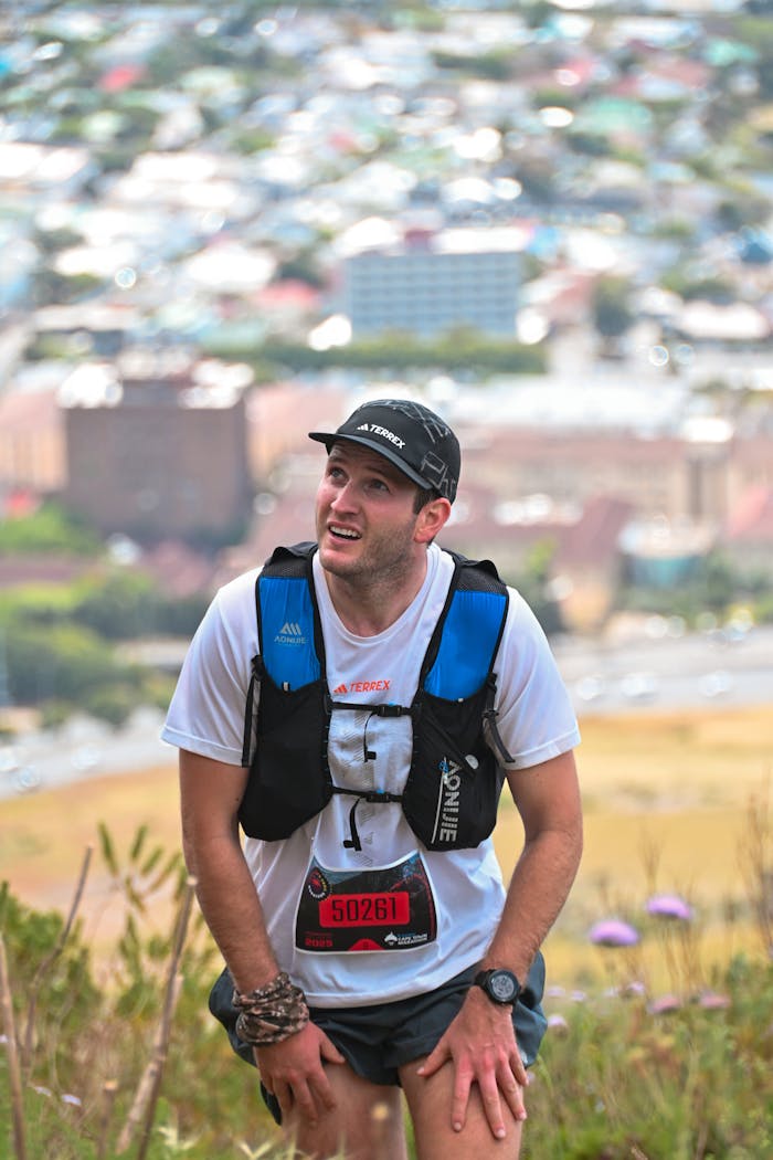 A trail runner taking a break with Cape Town's cityscape in the background.